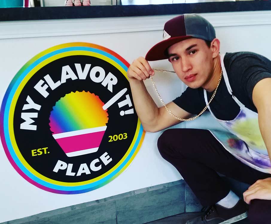 One of our staff posing by our logo