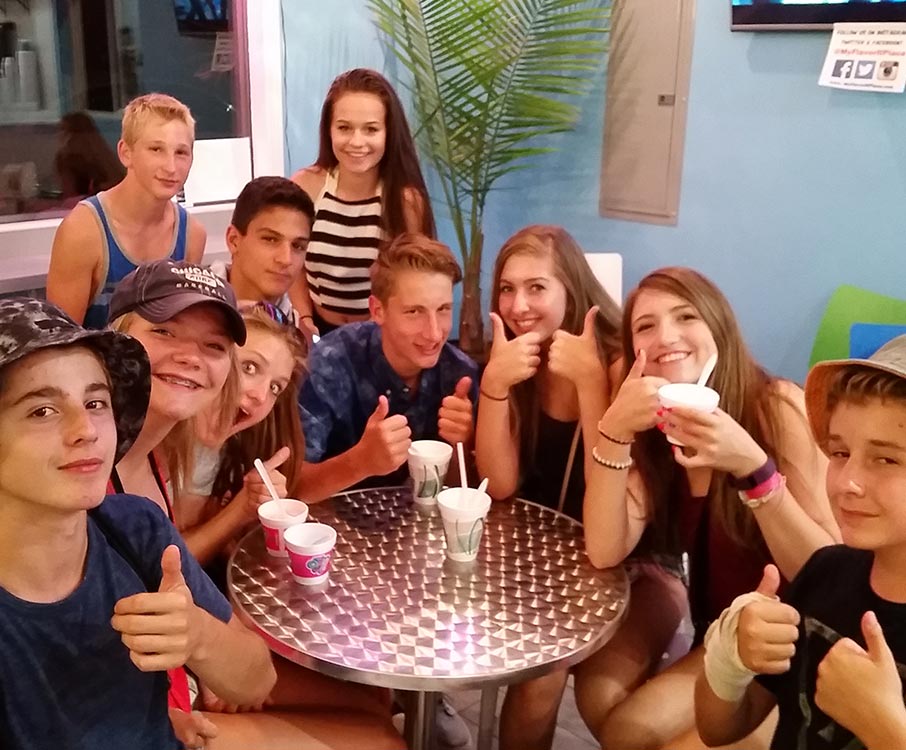 A group of teenagers at our ice cream shop giving thumbs up